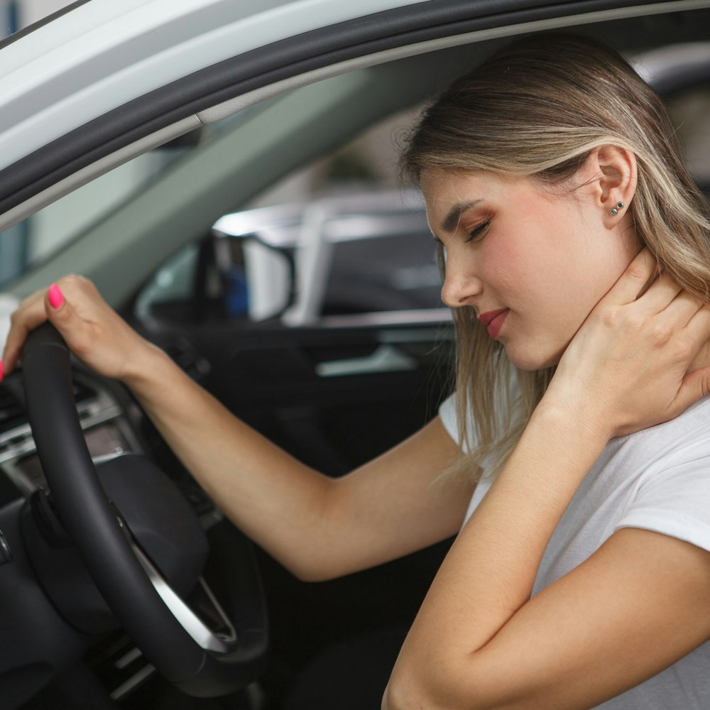 Woman holding neck in pain after car accident
